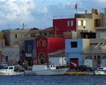  Colorful houses line the waterfront of Lampedusa.